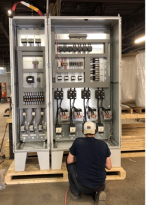 A plant worker operates temperature control panels.